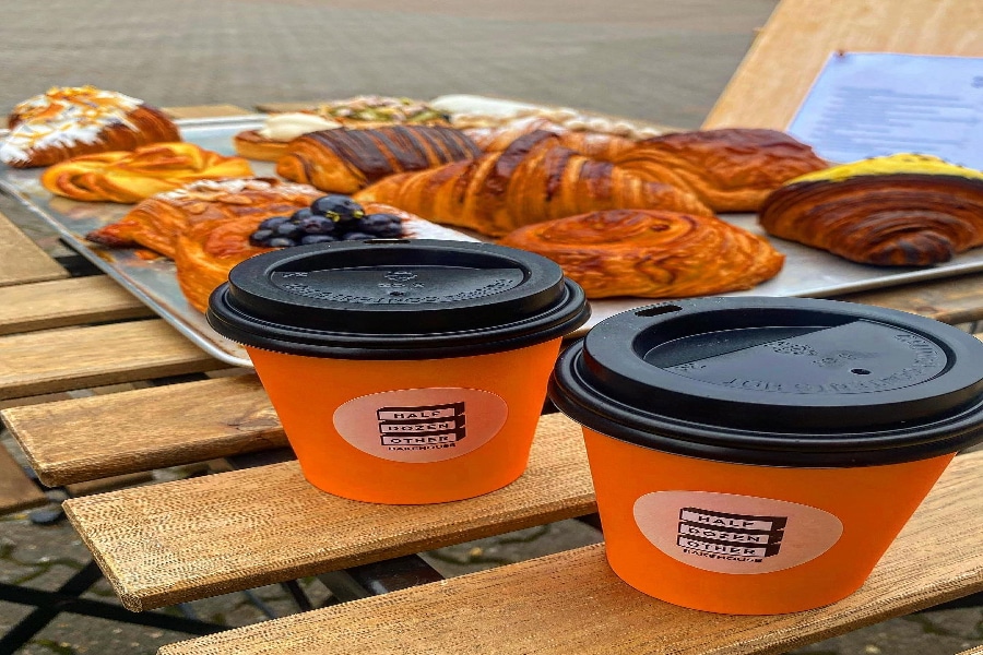 Two cups of coffee and a tray of Half Dozen Other pastries.