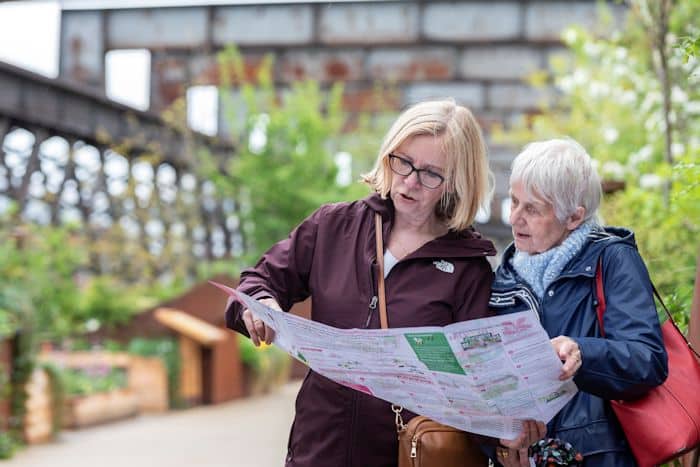 Two-women-looking-at-Bloomtown-map-on-Castlefield-Viaduct